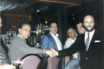 In a photo seized during a 1988 raid, mob boss John DiFronzo (far left) is seen shaking hands with a restaurateur. Marco D'Amico can just be seen peeking over the owner's shoulder.